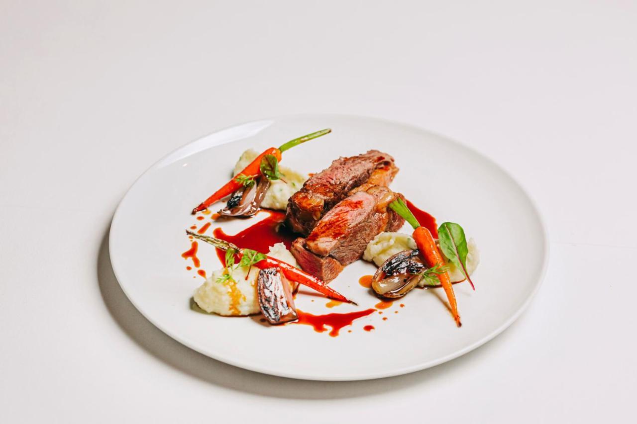 Ap Lago Montargil - Conference & Spa Eksteriør billede The photo features a beautifully plated dish. At the center, there are slices of a tender meat, likely beef, showcasing a juicy pink interior. Accompanying the meat are several elements: vibrant orange carrots, perhaps roasted or glazed, and dollops 